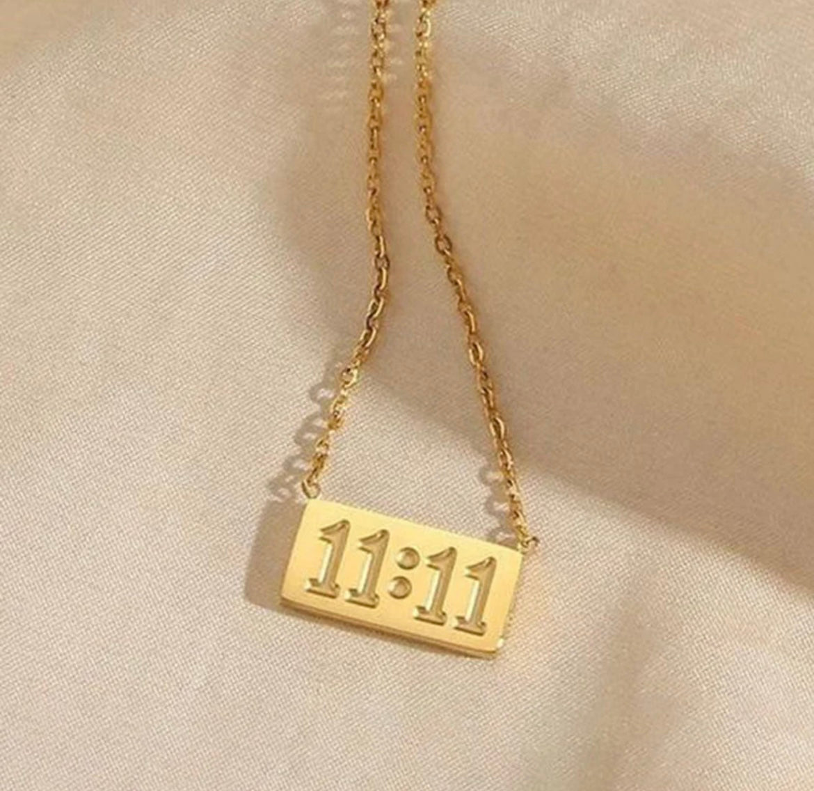 Gold necklace with rectangular pendant featuring embossed 11:11 number by ELL DESIGNS