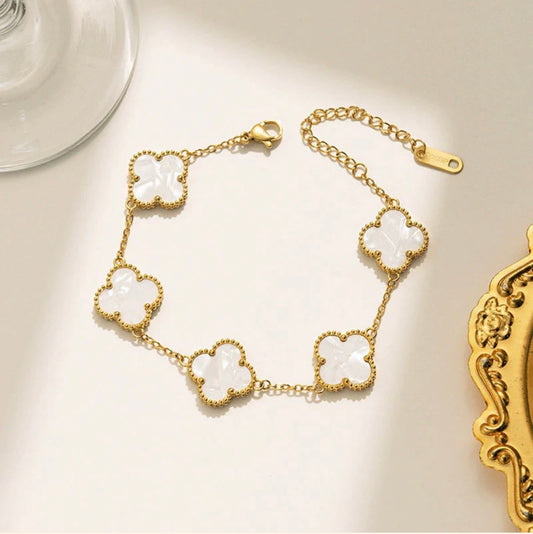 ELL DESIGNS gold bracelet with five white clover-shaped charms and adjustable chain