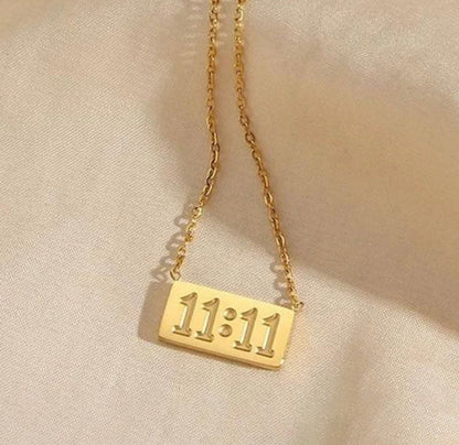 Gold necklace with rectangular pendant featuring embossed 11:11 number by ELL DESIGNS