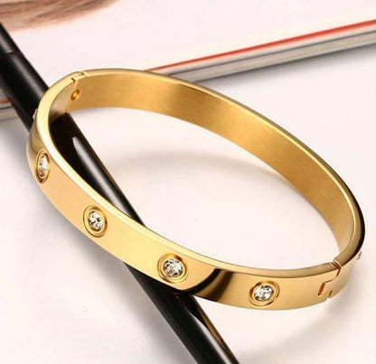 Gold-tone bangle bracelet with embedded clear crystals by ELL DESIGNS