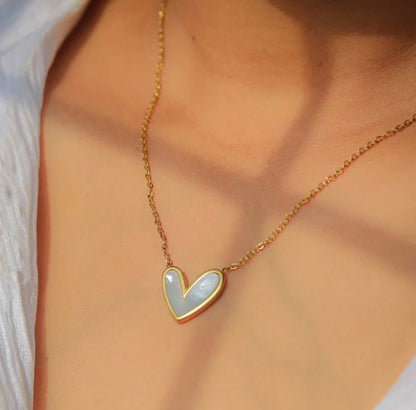 Gold chain necklace with white mother of pearl heart pendant by ELL DESIGNS worn on neck